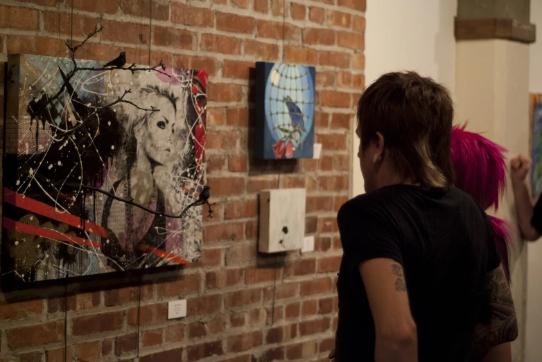 an image of woman looking at a painting