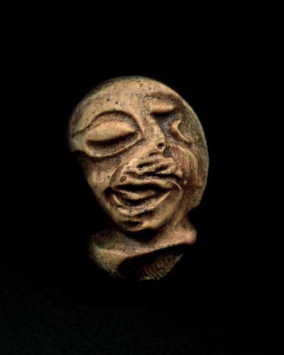 a statue of an alien head made of clay