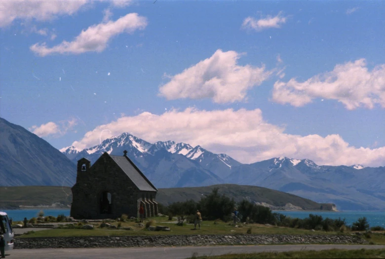 there is a small church in front of the mountain range