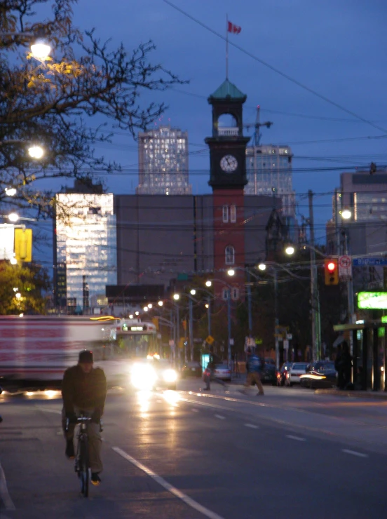 a bicyclist and cyclist cross the street at night