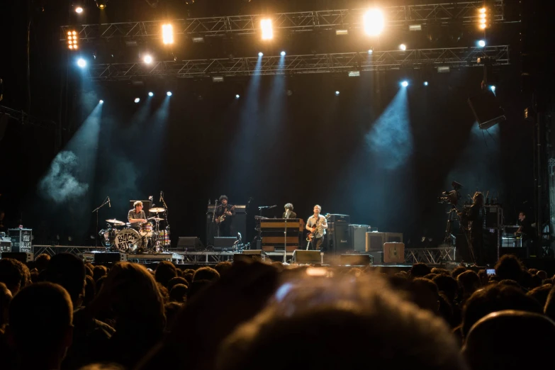 a band on stage performing with bright spotlights