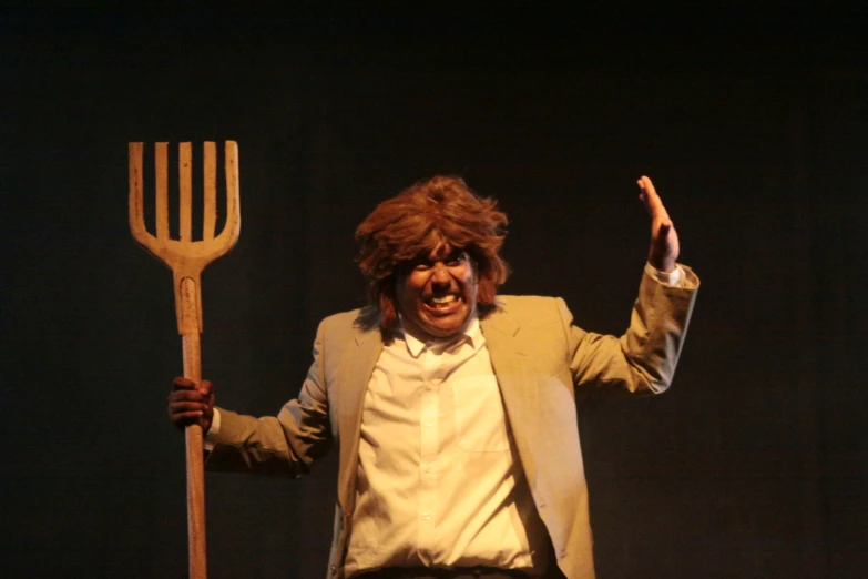 a man in a suit holding a pitchfork and pointing to the side