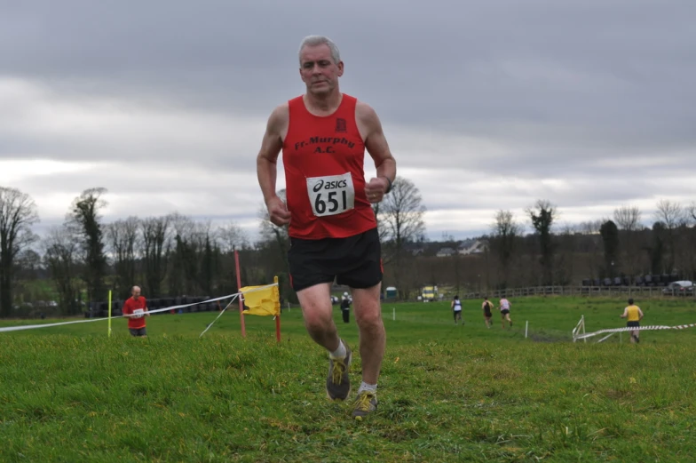 a man running on the grass with other men behind him