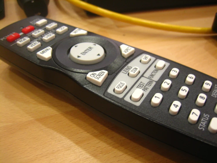 a black remote control on a wooden table