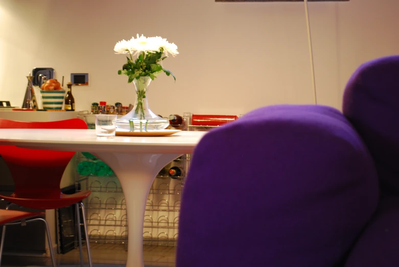 vase of flowers with multiple white flowers sit atop table