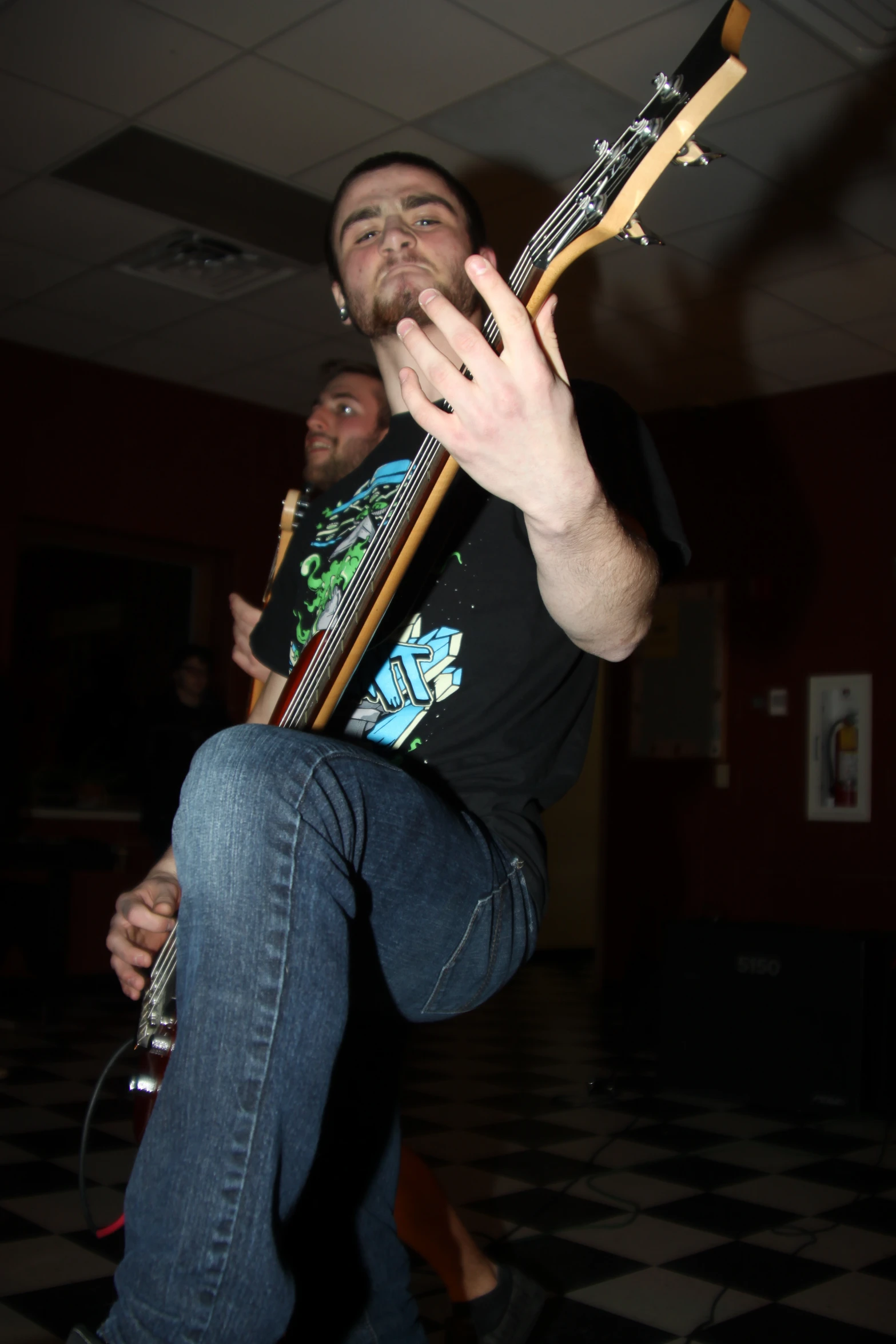 a young man holding a guitar and playing the guitar