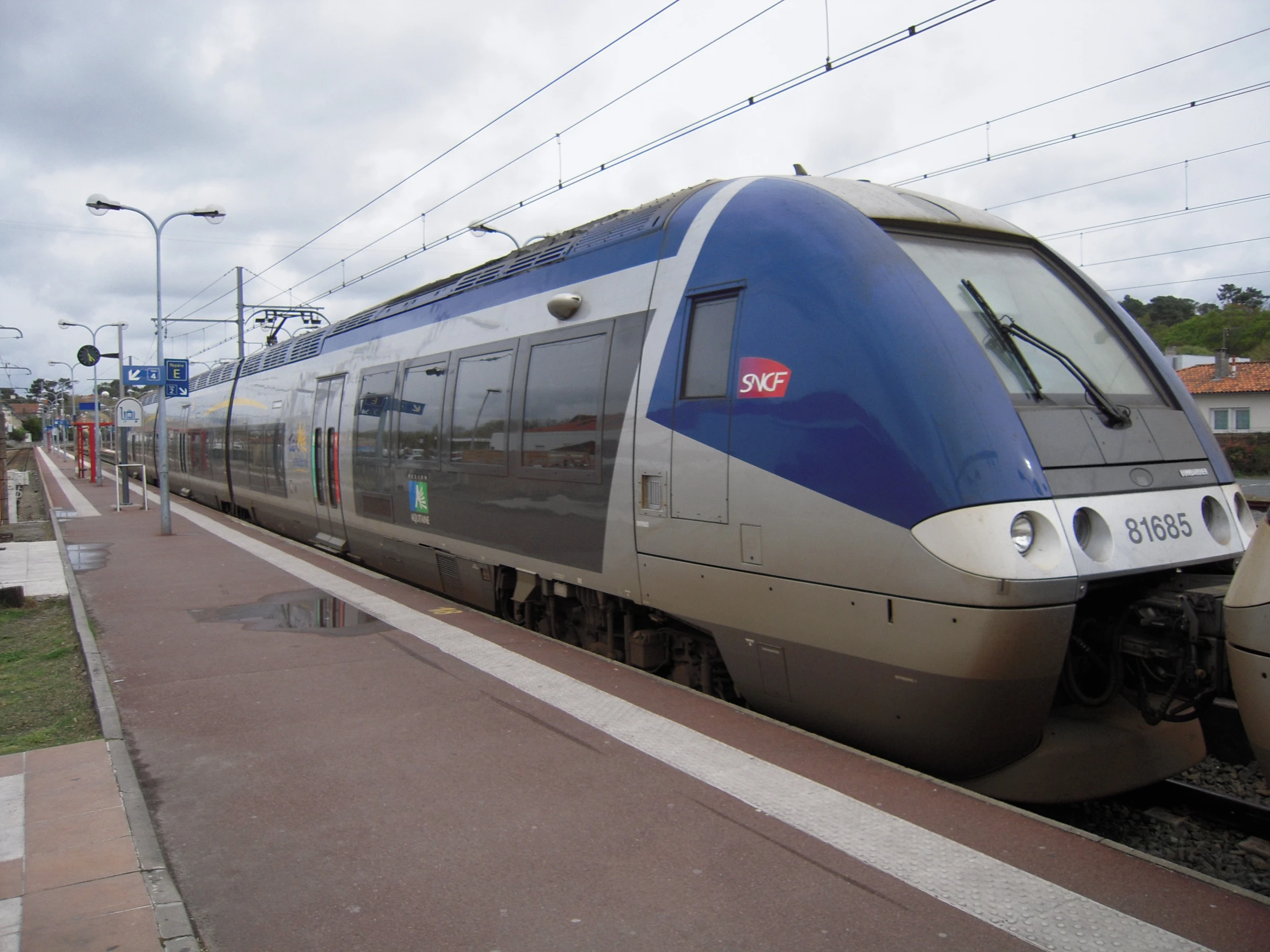 a blue and silver train is parked on the tracks