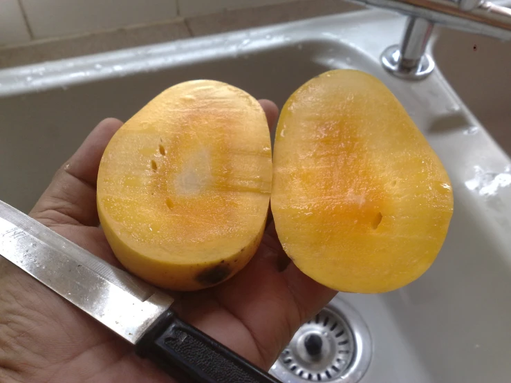 someone holding a banana near a kitchen sink