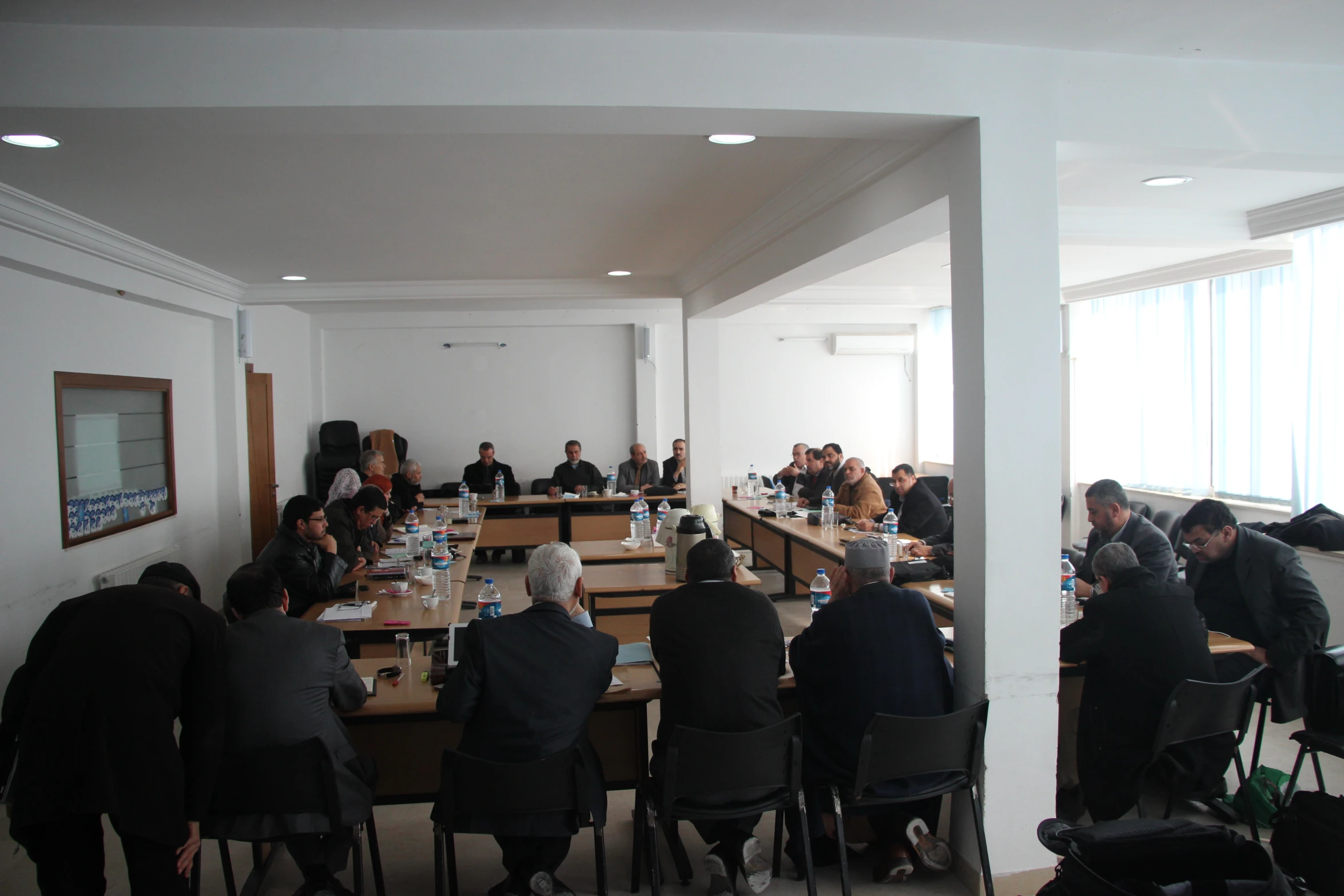 a group of people sitting at long tables in a room