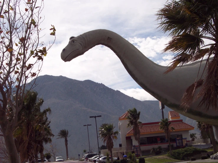 a strange white dinosaur statue in a town