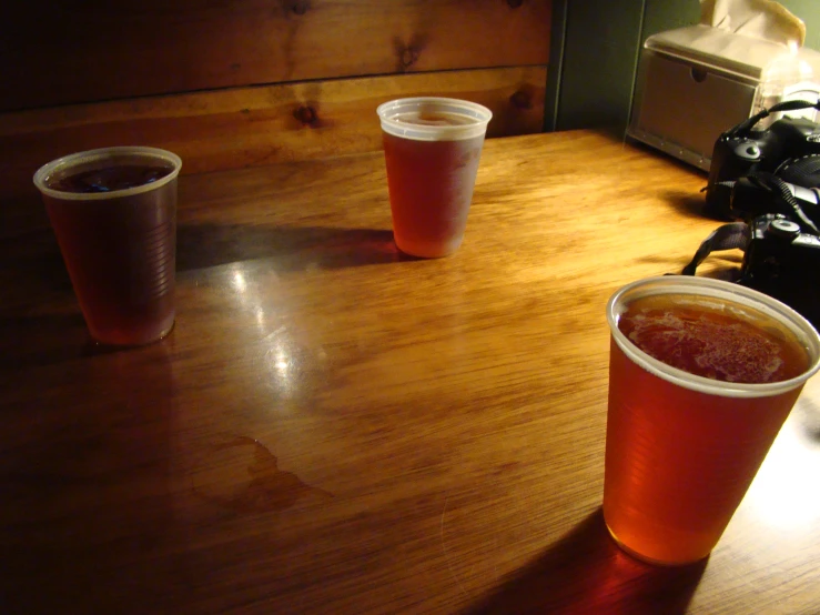 three glasses sit on a table next to each other