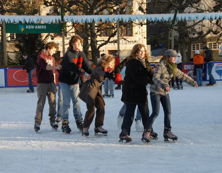 a group of people on skating on an outdoor rink