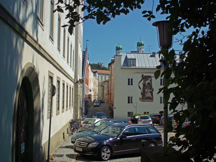 a row of cars is parked on a narrow street