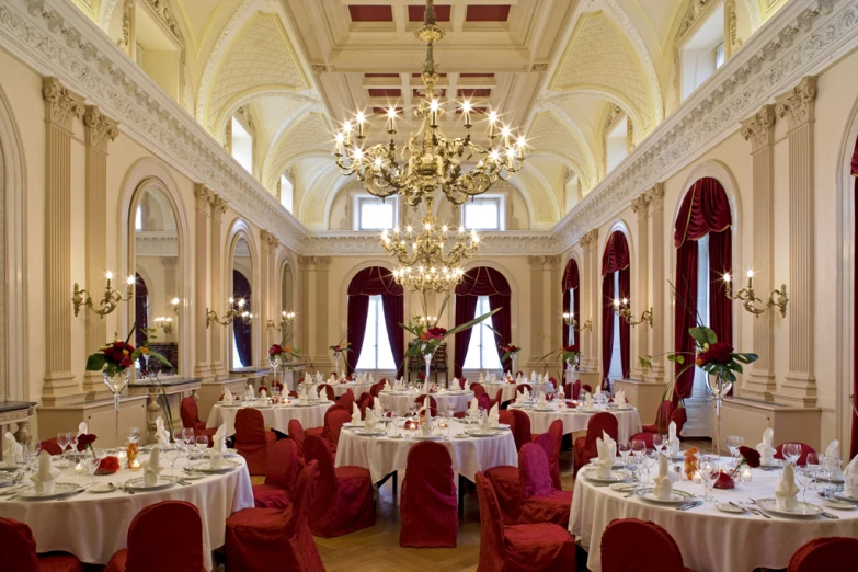 a fancy el setting features round tables and red chairs