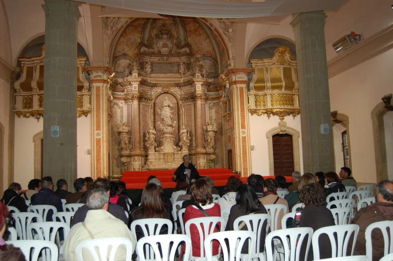 many people sitting in white chairs around each other