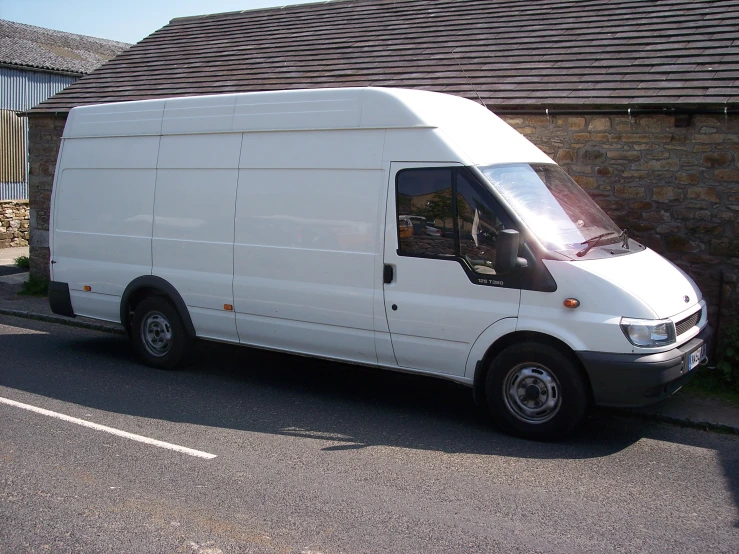 a small van is parked in front of a house