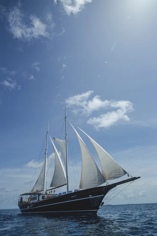 a boat sailing on the ocean with large sails