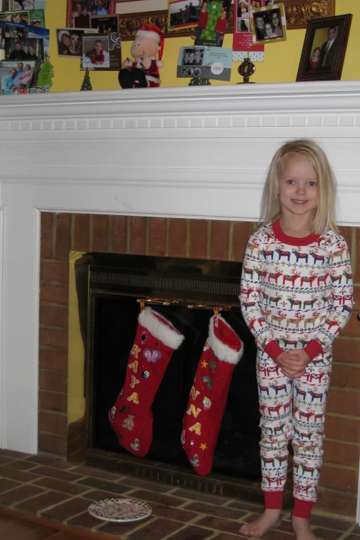 the  is standing next to her christmas stockings