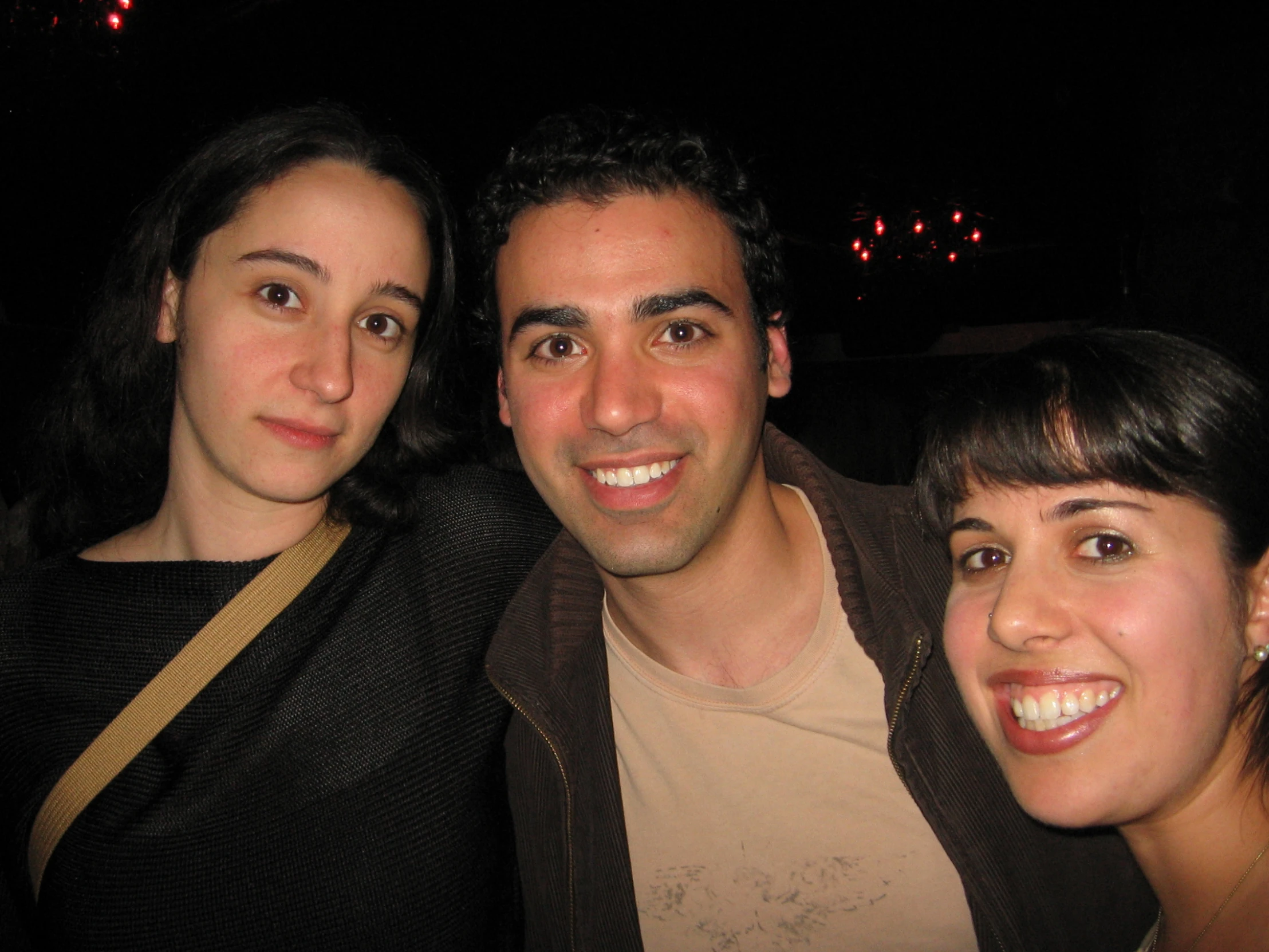 four friends pose for the camera, close up at night