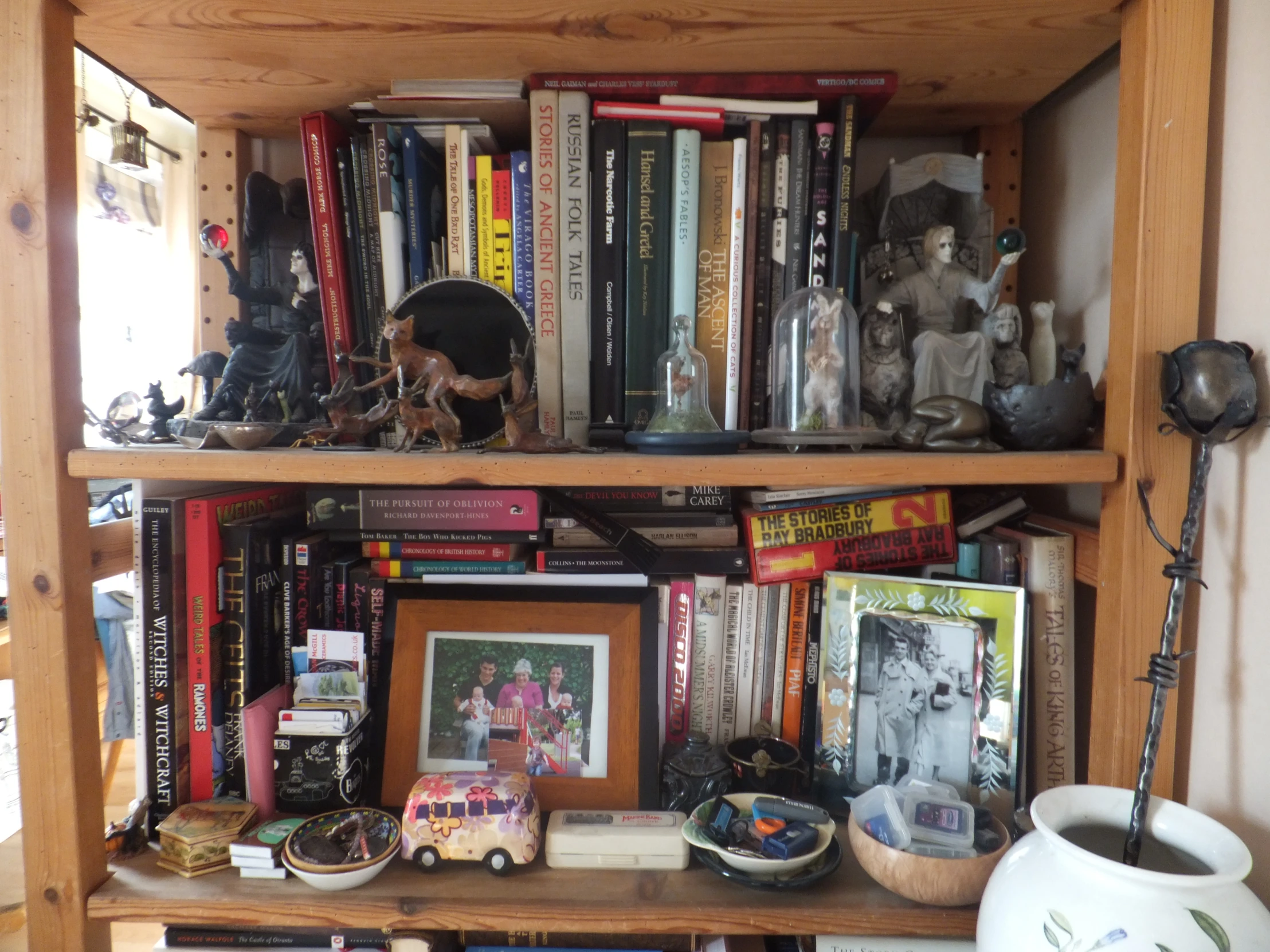 a shelf filled with books and figurines on top of it