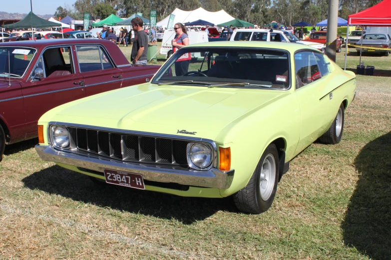 this bright green car is parked in a field