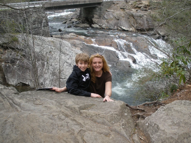 there is a woman and a child sitting on a rock