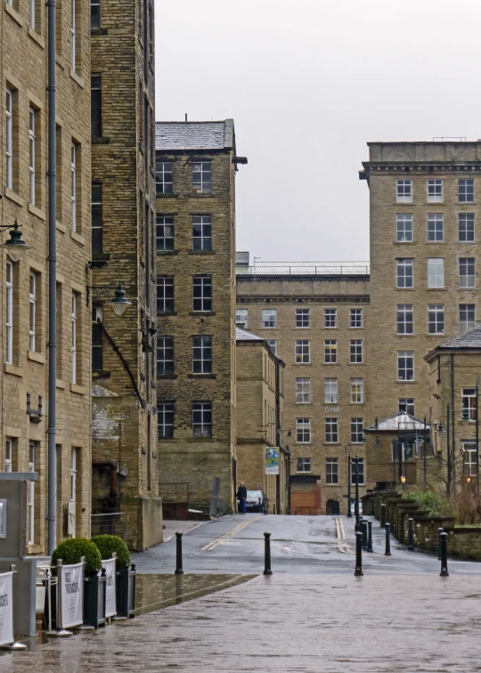 the walkway leads to several large buildings and an open lot