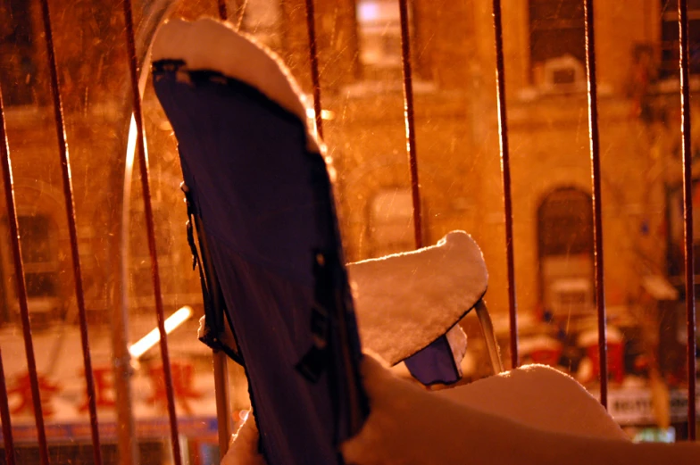 a chair sitting on a patio in front of a window with a curtain