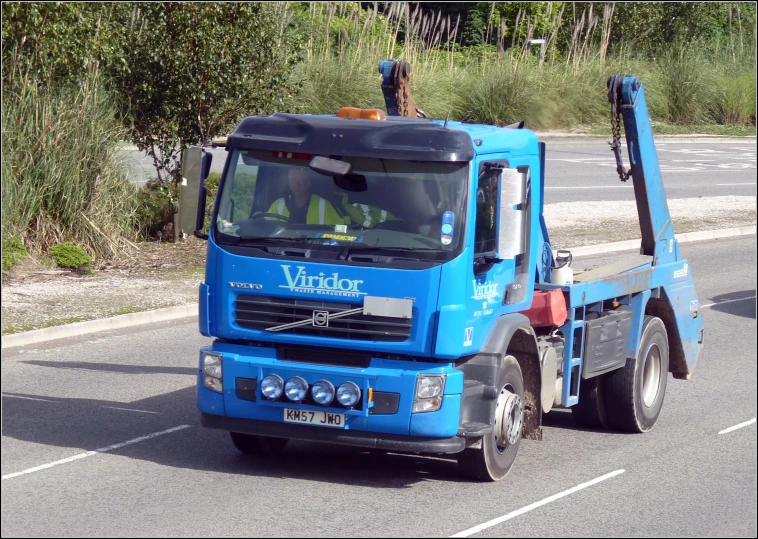 a blue truck sitting on the road next to the woods