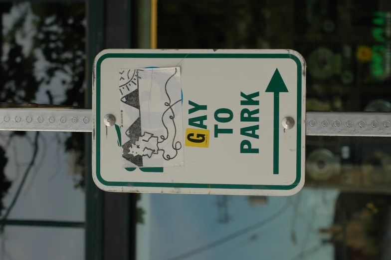 a sign on a metal pole reading gay to park