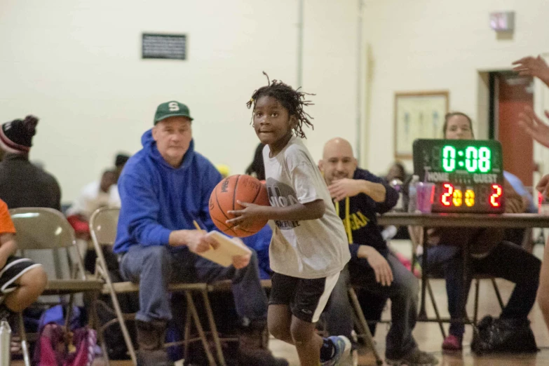 young man in white uniform playing basketball on indoor court