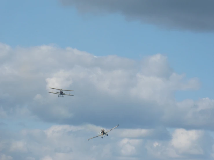 a plane flying through a cloudy blue sky