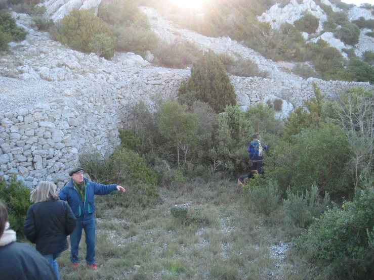 a group of people standing in the brush on a hill