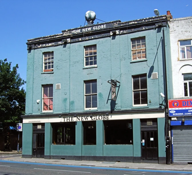 a tall blue building sits on the side of the road