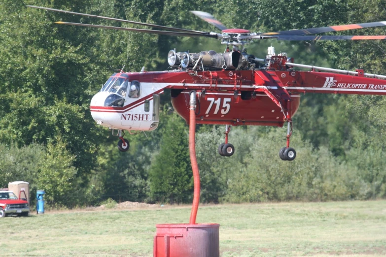 a red helicopter being assisted in a bush
