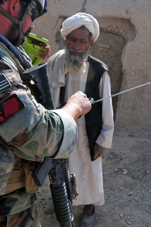 an afghan soldier with a sword near another person