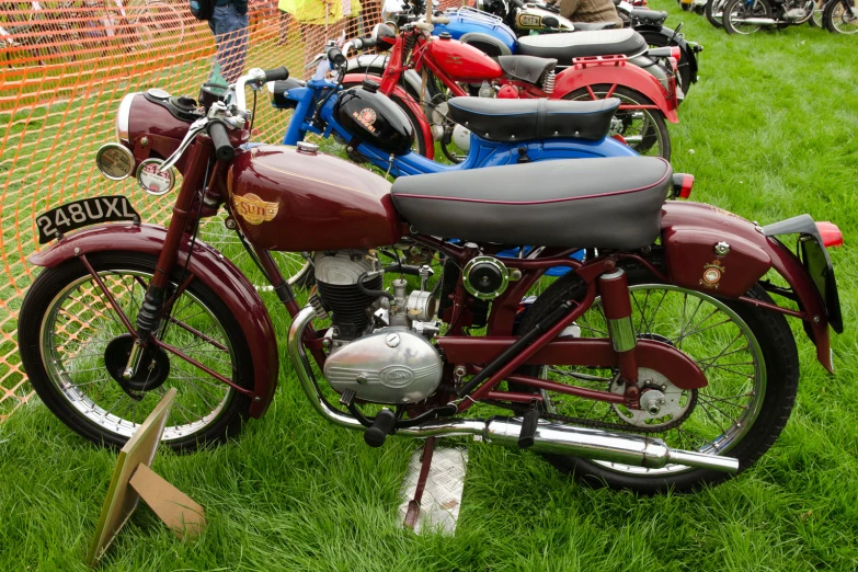 the classic motorcycles are lined up in front of a fence