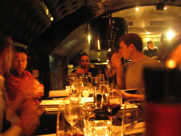several people sit around a dinner table in a restaurant