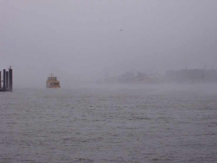 a foggy ocean with a large boat on the water
