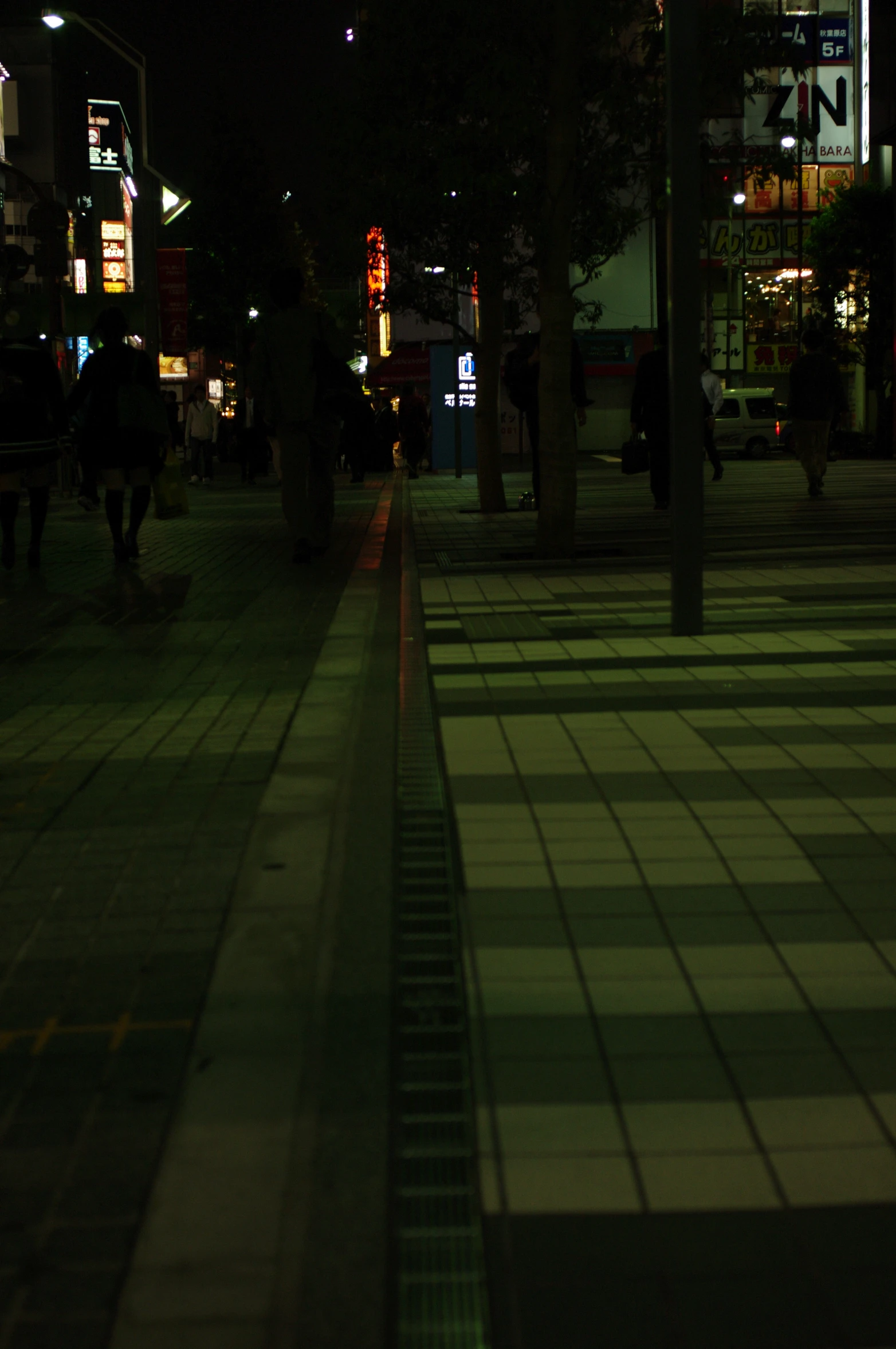 a walkway surrounded by city buildings at night