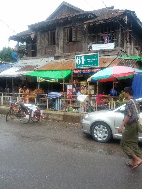 two cars stopped near a building in front of a busy street