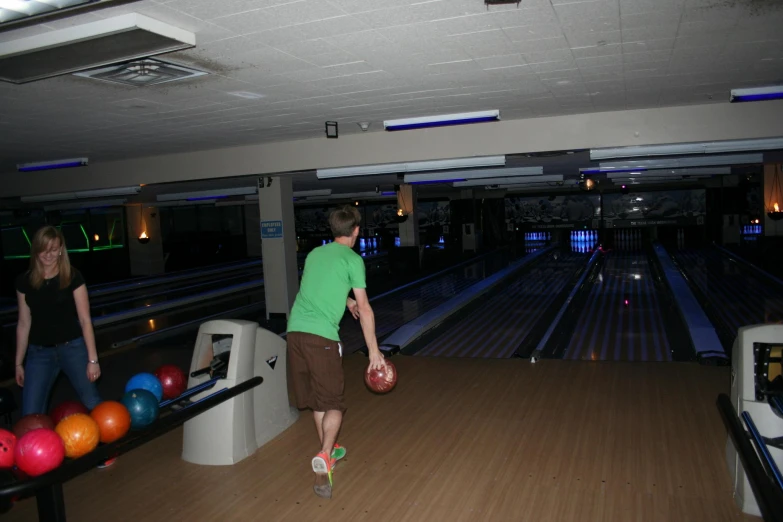 two men who are standing near bowling lanes