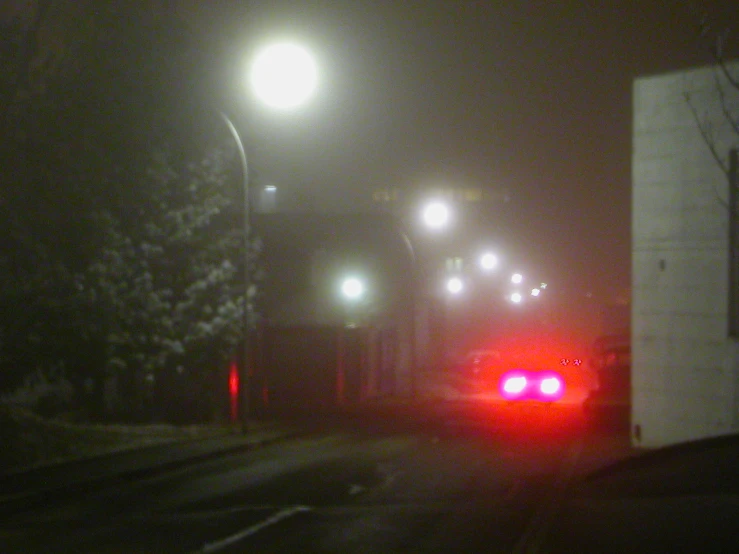 a car that is at night driving down the street