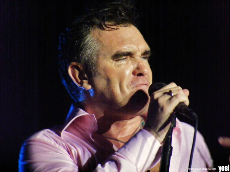 a man holding a microphone with his mouth open
