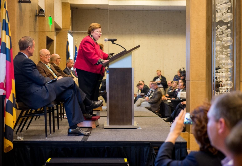 a woman standing at a podium giving a speech