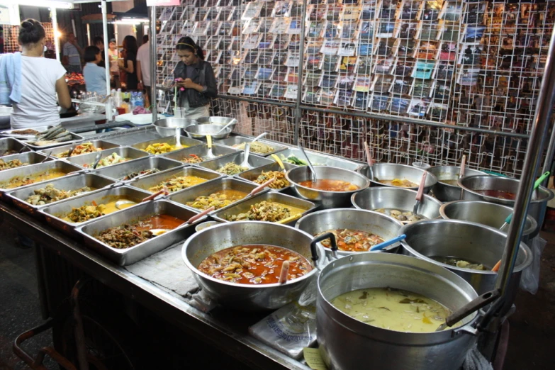 several metal bowls with food are sitting on top of a table