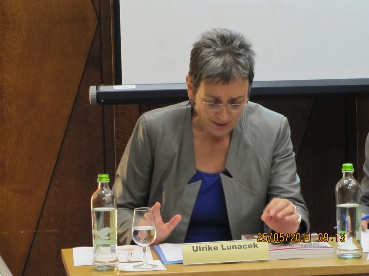 a lady with glasses speaking at a podium