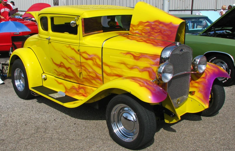 a yellow and red truck sitting next to other cars