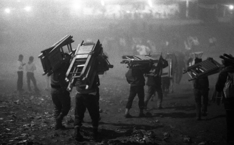 a group of people carrying their belongings across a field