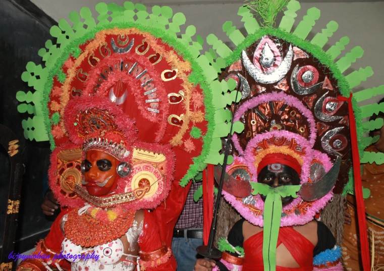 two people in colorful costumes on display for a pograph